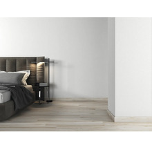 Lichte slaapkamer met tweepersoonsbed, nachtkastlamp en houten vloer