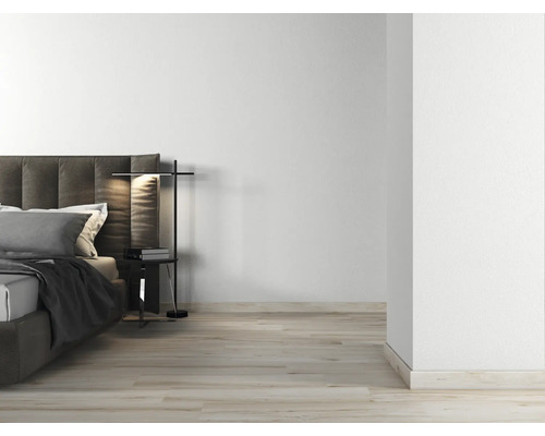 Lichte slaapkamer met tweepersoonsbed, nachtkastlamp en houten vloer