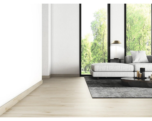 Lichte woonkamer met bank, tapijt, tafel en groot raam met uitzicht op groen.