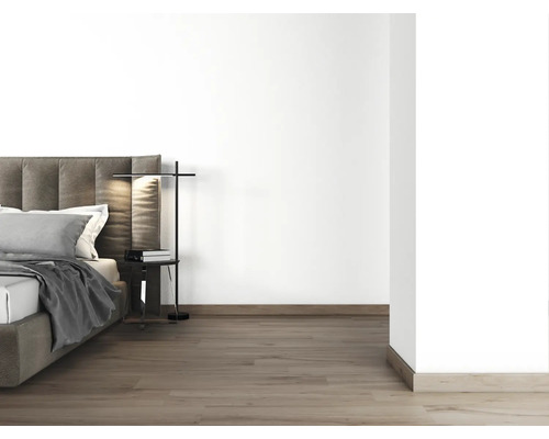 Slaapkamer met bed, nachtkastje en vloerlamp