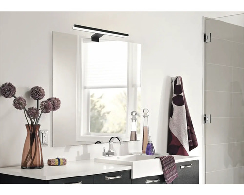 Moderne badkamer met wastafel, spiegel, lamp en decoraties.