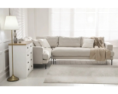 Lichte woonkamer met bank, commode en staande lamp