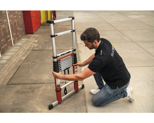 Man die een aluminium telescopische ladder inklapt