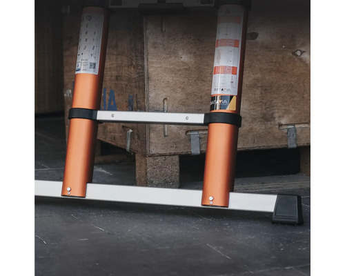Uitgeschoven aluminium ladder voor een houten kist