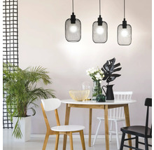 Eetkamer met eettafel, stoelen en drie zwarte hanglampen