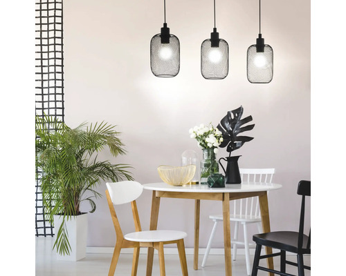 Eetkamer met eettafel, stoelen en drie zwarte hanglampen