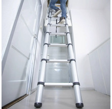 Persoon beklimt een uitschuifbare aluminium zolderladder in een huis