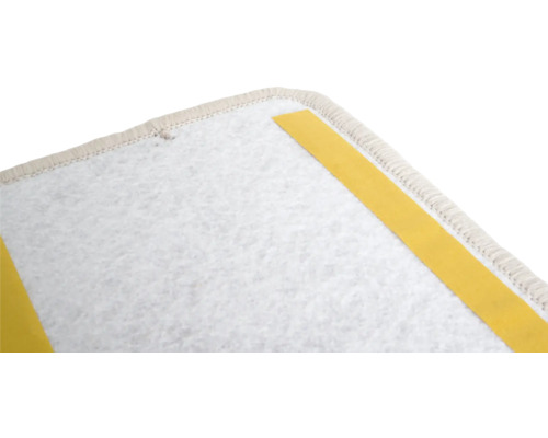 Gedetailleerde opname van een tapijtruggen met plakstrips voor bevestiging.