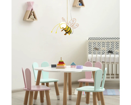 Kinderkamer met een tafel, stoelen en een hanglamp in de vorm van een bij