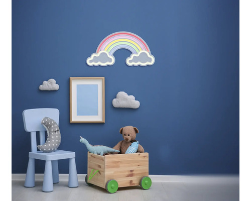 Kinderkamer met speelgoedkist, stoel en wanddecoraties zoals wolken en een regenboog