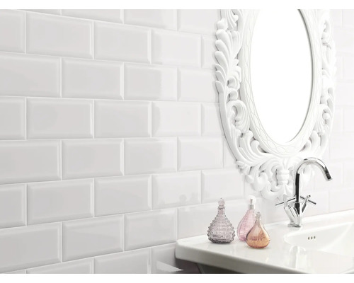 Badkamer met witte metro tegels, wastafel en spiegel