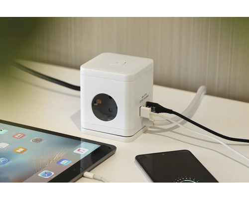 Witte stroomkubus met USB-aansluitingen en stopcontacten in gebruik met tablet en smartphone