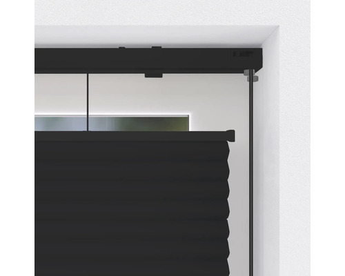 Detailopname van een zwart plisségordijn voor een raam