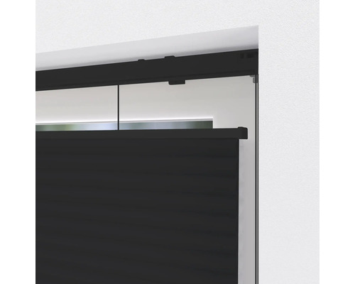 Detailopname van een zwart plisségordijn op een raam