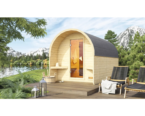 Houten barrel sauna met glazen deur en twee ligstoelen op een houten terras met een berglandschap op de achtergrond