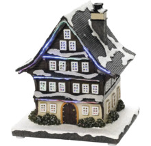 Decoratief, verlicht miniatuurhuis met sneeuw voor kerstdecoratie