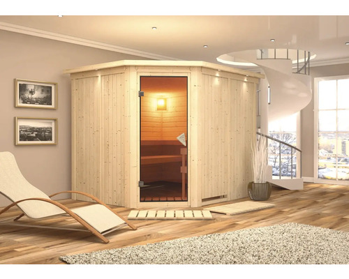 Houten binnensauna met glazen deur in een lichte kamer met ligstoel en wenteltrap