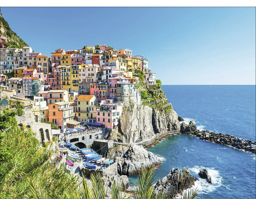 Uitzicht op Manarola, een kustplaats in Italië, met kleurrijke huizen op een klif boven de zee.