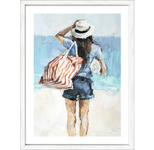 Schilderij van een vrouw op het strand met hoed en tas in een witte lijst