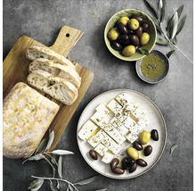 Stilleven met brood, feta, olijven en olijfolie op een tafel.