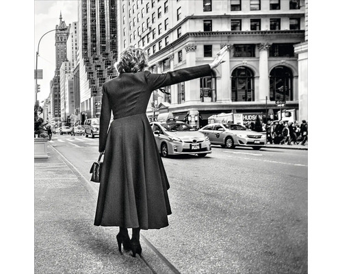 Zwart-witfoto van een vrouw die een taxi aanhoudt in een stedelijke straat