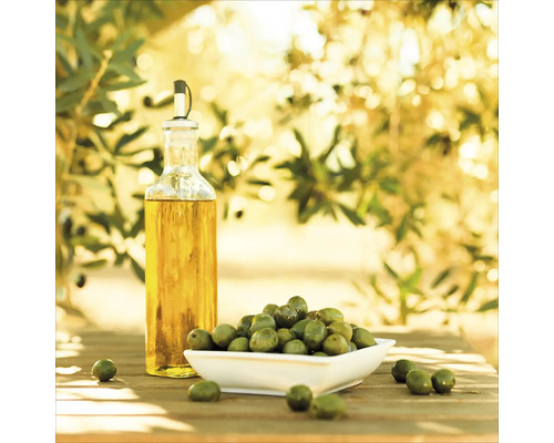 Olijfolie fles en groene olijven in schaal op houten tafel
