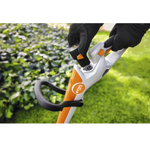 Een persoon plaatst een batterij in een draadloze grastrimmer.