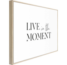 Decoratieve muurkunst met de tekst ''Leef in het moment''.