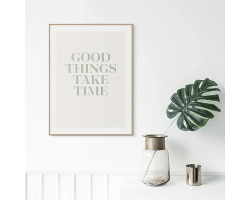 Decoratieve ingelijste poster met de tekst goede dingen kosten tijd, een vaas en een blad op een tafel