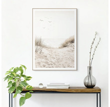 Decoratieve ingelijste muurafbeelding met strandthema boven een consoletafel