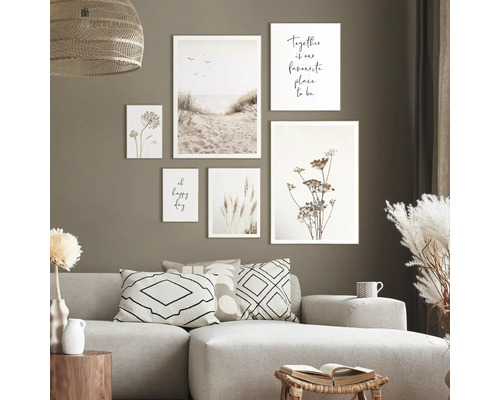 Woonkamer met bank en diverse muurafbeeldingen met plantmotieven en strandgezichten