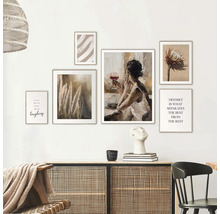 Decoratieve wand met ingelijste kunstwerken boven een dressoir