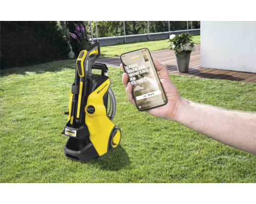 Kärcher hogedrukreiniger K5 Power Control met smartphone in een hand op gazon