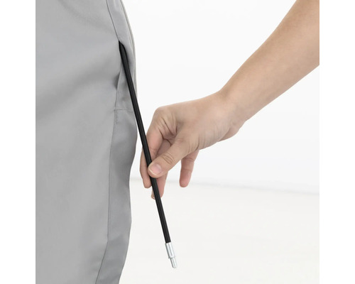 Persoon steekt een tentstok door een stoffen oogje