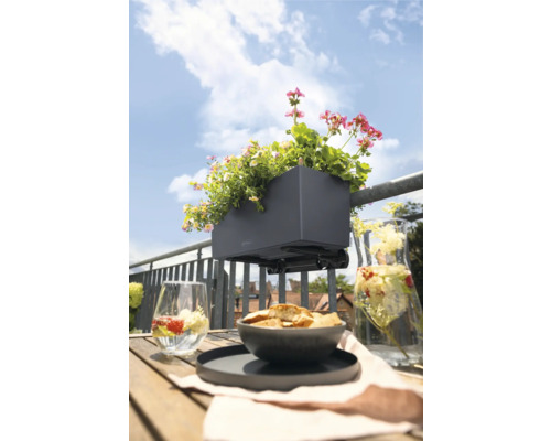 Balkonscène met bloembak en zomerse decoratie op houten tafel