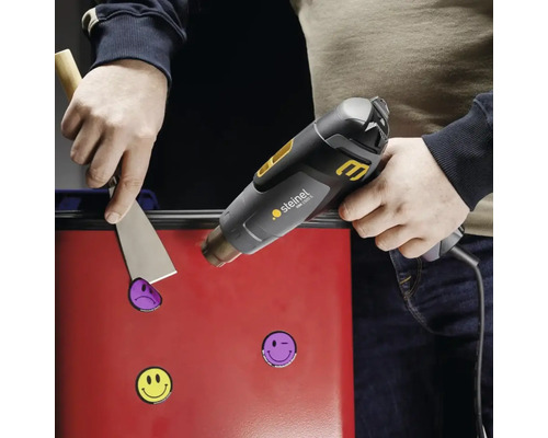 Toepassing van een heteluchtpistool om stickers van een oppervlak te verwijderen met een plamuurmes