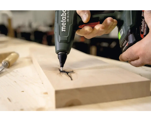 Metabo lijmpistool brengt lijm aan op een houten plank
