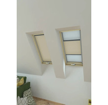 Twee dakramen met rolgordijnen voor privacy in een lichte kamer.