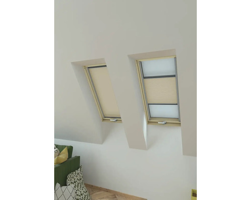 Twee dakramen met rolgordijnen voor privacy in een lichte kamer.