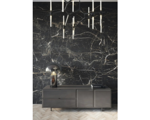 Decoratief interieur met ladekast, lamp, plafondlamp en wandtegels in marmerlook.