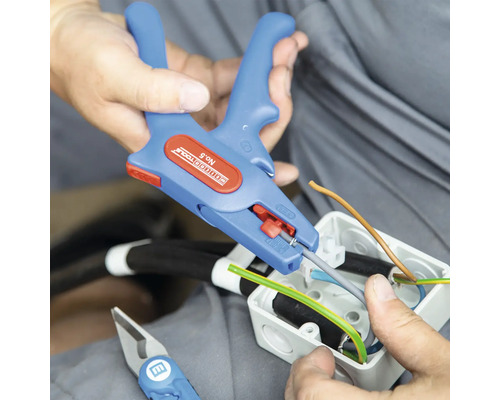 Elektricien gebruikt een draadstripper om draden te bewerken in een aansluitdoos.