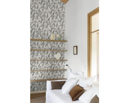 Woonkamer met patroonbehang, houten planken en witte bank.