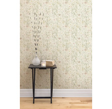 Een close-up van een muur met bloemenbehang en een bijzettafel met decoratieve items zoals een vaas, een theelicht en boeken.