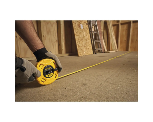 Persoon rolt een gele Stanley rolbandmaat van 20 meter uit