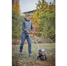 Man gebruikt een tuinfrees voor grondbewerking in de tuin.