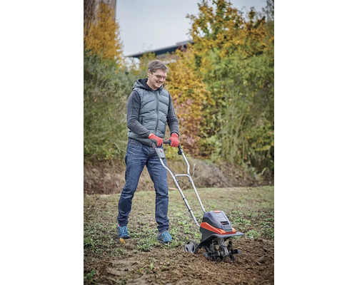 Man gebruikt een tuinfrees voor grondbewerking in de tuin.