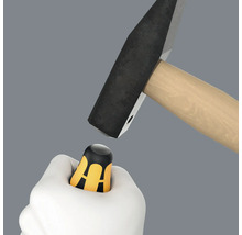 Hand houdt duimbeschermer onder hamer