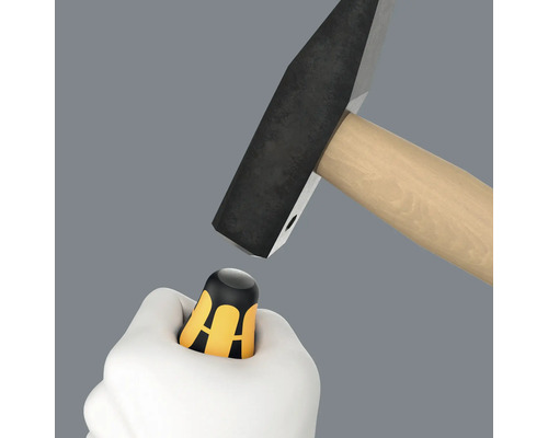 Hand houdt duimbeschermer onder hamer