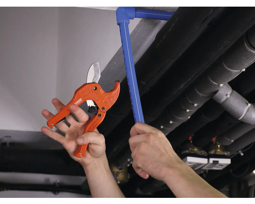 Pijpsnijder snijdt plastic buis in installatie