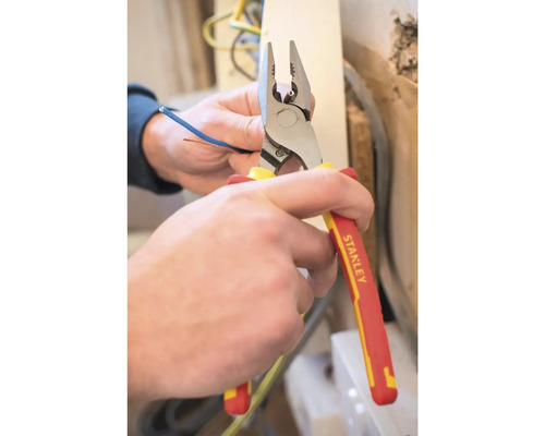 Een persoon knipt een kabel door met een combinatietang.